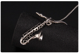 Macro shot of vintage silver saxophone pendant with detailed musical instrument carvings