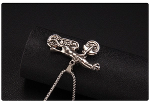 Macro shot of silver motorcycle pendant featuring detailed engine parts and industrial style