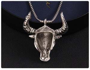 Gros plan du pendentif tête de taureau vintage avec gravures et chaîne à mailles box