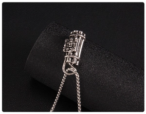 Macro detail of silver punk bomb pendant necklace with intricate wire and timer relief