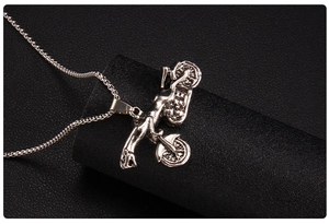 Detailed macro shot of vintage silver motorcycle pendant with punk mechanical details