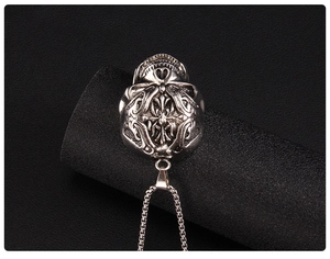Macro view of vintage silver gothic cross pendant with intricate scroll relief details