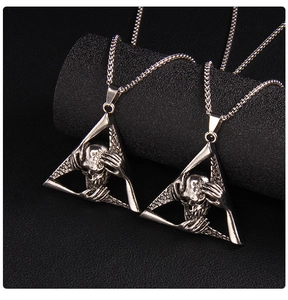 Macro shot of gothic silver skull pendant with hands on head in a triangle frame
