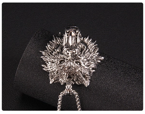 Macro close-up of a lifelike wolf head pendant featuring detailed steel textures and sharp fangs