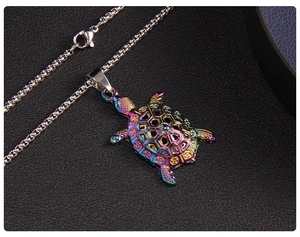 Macro view of a colorful rainbow turtle pendant with geometric cutouts on a steel chain