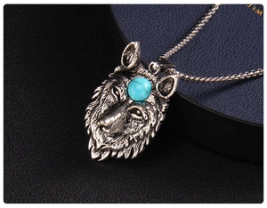 Macro shot of retro wolf head pendant with blue gemstone and detailed silver texture