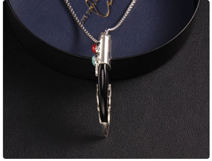 Macro shot of ethnic wolf tooth pendant with red and blue beads on a silver ball chain