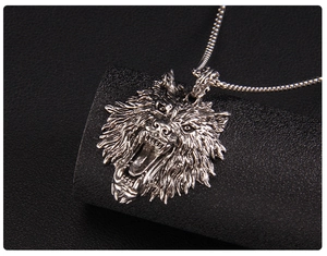 Macro shot of stainless steel wolf head pendant with detailed textures on leather