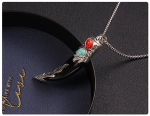 Macro detail of retro wolf tooth pendant with ornate carving and dual-tone gems