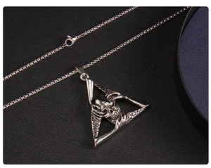 Macro detail of gothic punk stainless steel skull pendant with skeletal hands
