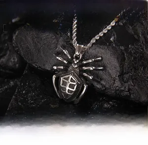 Macro detail of gothic stainless steel spider pendant with textured abdomen on dark stone