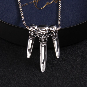 Punk style stainless steel necklace featuring triple skull and claw pendants on a box chain