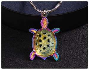 Macro detail of rainbow turtle pendant with diamond hollow shell on silver snake chain