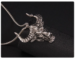 Gros plan du pendentif tête de taureau vintage en argent avec détails sur fond noir
