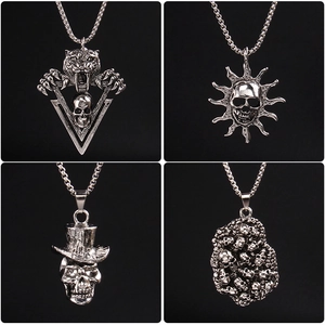 Silver punk skull necklaces with saber-tooth, sun, and top hat designs on black background