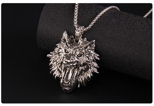 Detailed close-up of antique silver wolf head pendant with intricate 3D carving on square chain