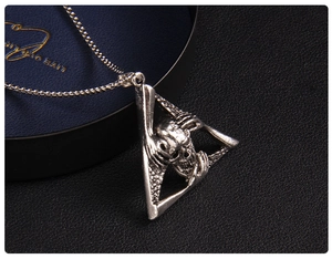 Macro shot of gothic skull pendant in triangle frame with antique silver box chain