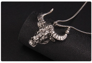 Gros plan du pendentif tête de taureau en argent vieilli avec chaîne à billes