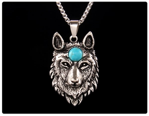 Macro shot of a stainless steel wolf head pendant with sapphire blue stone inlay
