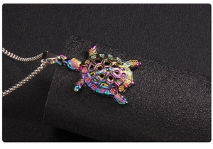 Macro shot of colorful iridescent sea turtle pendant with hollow geometric shell pattern