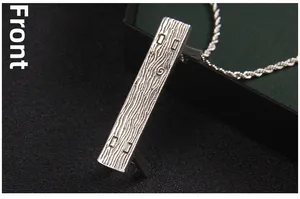 Front view detail of a silver stainless steel pendant with wood grain texture and chain