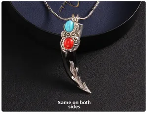Detail view of a vintage wolf tooth pendant with turquoise stones and double-sided design