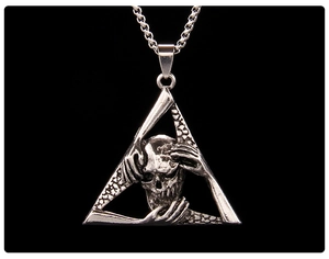 Macro shot of punk gothic 3D skull pendant with hands in triangular stainless steel frame