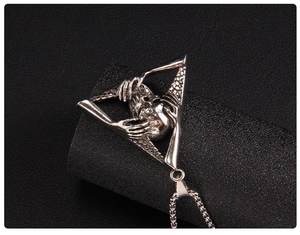 Macro shot of vintage punk skull necklace featuring a gothic triangle skeleton pendant