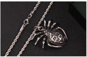 Close-up of silver spider pendant with rope chain and lobster clasp on black leather