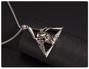 Macro shot of gothic skeleton pendant in triangle frame with vintage silver finish
