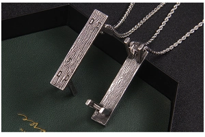 Macro shot of rectangular pendant showing textured wood grain and vintage silver finish