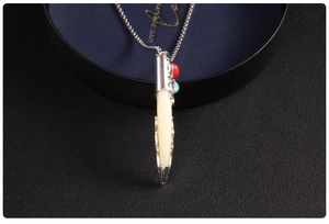 Detail of vintage wolf tooth pendant with silver chain and red blue beads on leather
