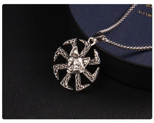 Détail macro du pendentif loup argenté avec symbole Kolovrat et motif de nœud celtique