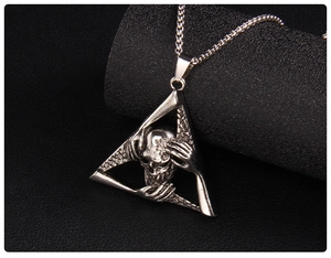 Macro view of gothic skull triangle pendant featuring detailed triple hand engraving