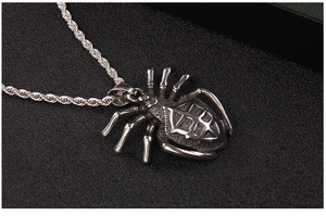 Detailed macro view of an antique silver spider pendant with a textured rope chain