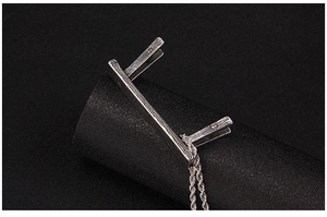 Macro view of vintage silver stool pendant with wood grain texture on twisted rope chain