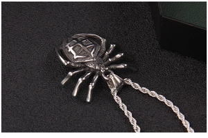 Macro detail of gothic spider pendant with vintage silver finish and twisted rope chain