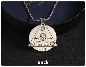 Makroaufnahme von Vintage Edelstahl Anhänger mit graviertem Totenkopf und Okkult-Symbolen