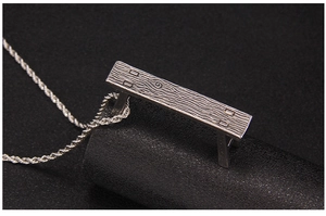 Macro detail of silver chair pendant showing realistic wood grain texture and rope chain
