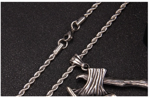Vue rapprochée du pendentif hache en acier inoxydable avec chaîne corde et finition antique