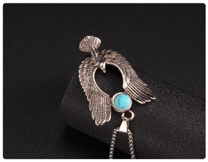 Nahaufnahme eines Adler-Anhängers mit Türkis-Inlay und feinen Flügeldetails an Silberkette