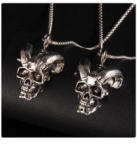 Macro detail of gothic bull skull pendants with curved horns on black leather