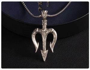 Macro shot of silver trident pendant with embossed details on a black jewelry box