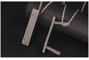 Macro shot of silver stainless steel rectangular pendant with fine wood grain texture