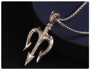 Macro shot of trident pendant with vintage texture and detailed gothic engraving