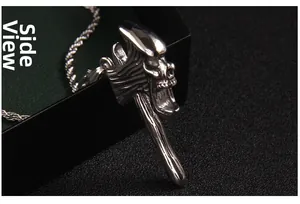 Vue latérale détaillée du pendentif hache punk gothique en acier avec tête de mort