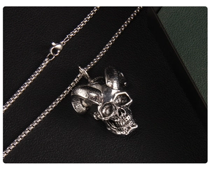 Detail of gothic silver ox horn skull pendant with vintage texture on leather background