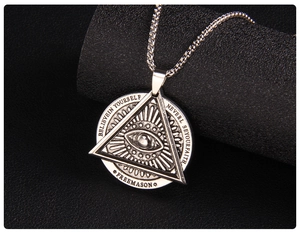 Makroaufnahme von Silberanhänger mit Auge der Vorsehung und gravierter Freemason-Basis