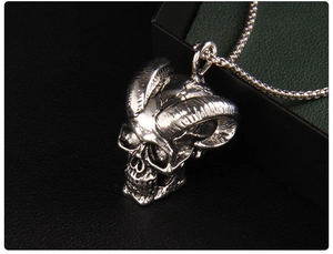 Macro shot of gothic ram skull pendant with antique finish on silver box chain