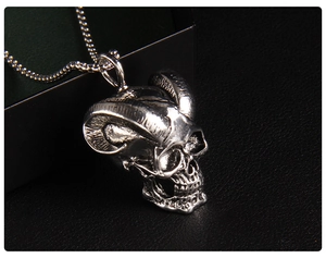 Macro side view of vintage silver ram skull pendant with intricate horn textures